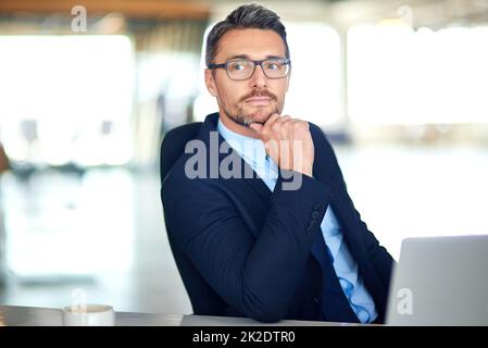 In Anbetracht seiner Optionen. Aufnahme eines durchdachten Geschäftsmannes, der im Büro einen Laptop benutzt. Stockfoto