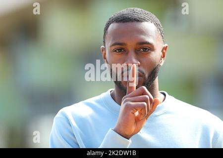 Ein Mann mit schwarzer Haut, der auf der Straße um Ruhe bittet Stockfoto