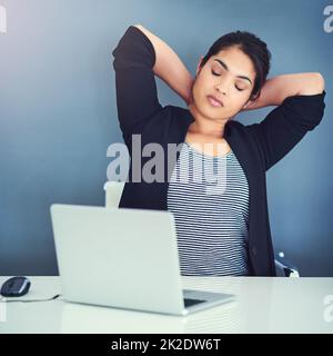 Alles, was ich jetzt brauche, ist eine Pause. Eine kurze Aufnahme einer schönen jungen Geschäftsfrau in ihrem Büro. Stockfoto