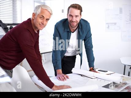 Begeistert von dem Projekt. Beschnittenes Porträt zweier männlicher Architekten, die in ihrem Büro zusammenarbeiten. Stockfoto