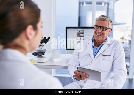 Unsere Forschung ist fast zur Veröffentlichung bereit. Aufnahme von zwei Wissenschaftlern, die in einem Labor diskutieren. Stockfoto