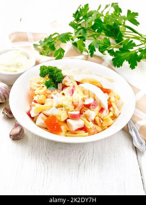 Salat mit Surimi und Tomaten mit Eiern auf dem Tisch Stockfoto