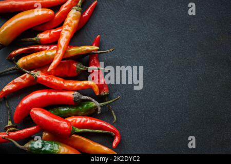 Je heißer, desto besser. Eine Aufnahme frischer roter Chilischoten aus einem hohen Winkel auf einer Küchentischfläche. Stockfoto