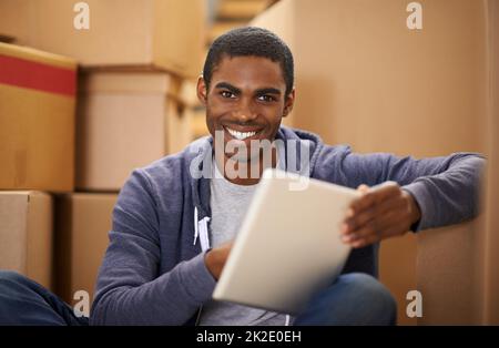 HES Umzug. Ein hübscher junger Mann, der Kisten verpackt. Stockfoto