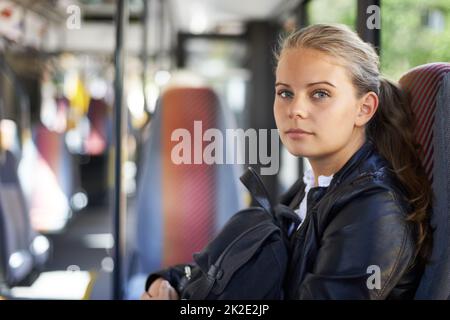 Öffentliche Verkehrsmittel bringen sie dorthin, wo sie hinwill. Ein Mädchen im Teenageralter, das auf dem Weg von der Schule nach Hause im Bus sitzt. Stockfoto