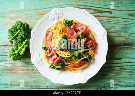 Leckere würzige pasta Linguine mit gebratenen Kohl Kohl, Speck, Knoblauch und Parmesan auf einer weißen Platte. Ansicht von oben Stockfoto