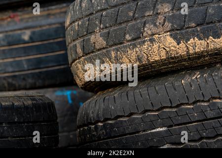 Stapel alter Reifen. Stapel gebrauchter Reifen. Schwarzer Gummireifen des Autos. Verschmutzte Altreifen. Altreifen zum Recycling schließen. Spurweite eines alten, schmutzigen Reifens. Autoreifen für Sicherheitskonzept wechseln. Stockfoto