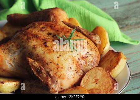 Ganzen gebratene Hähnchen mit Kartoffeln und Zitrone Stockfoto