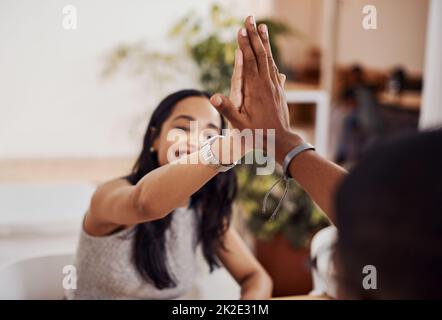 Oben. Aufnahme von zwei Geschäftsleuten, die sich in einem Büro gegenseitig eine hohe fünf geben. Stockfoto