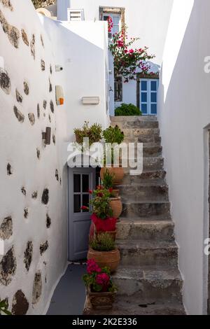 Keramik-Blumentöpfe auf steilen Steintreppen in Imergovigli, Santorini, Griechenland Stockfoto