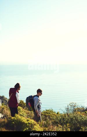 Die Berge rufen. Aufnahme eines jungen Paares, das auf einem Wanderweg die Natur erkundet. Stockfoto