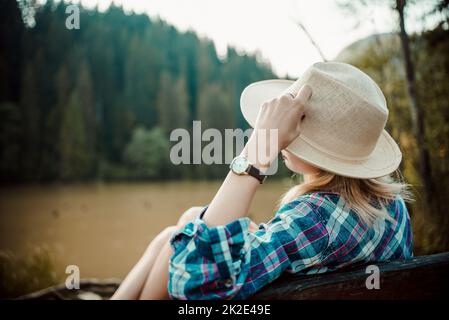 Rückansicht einer jungen Frau in Jeansshirt und Hut Stockfoto