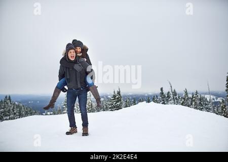 Waren bis zum Schnee gut. Aufnahme eines glücklichen jungen Paares, das sich beim draußen im Schnee amüsieren kann. Stockfoto