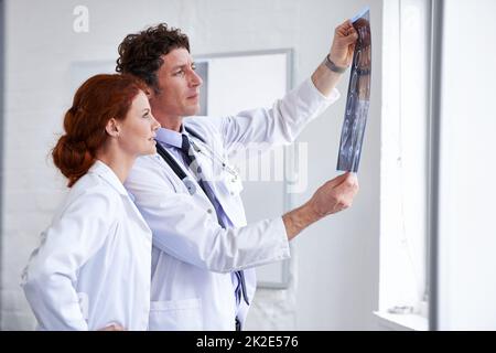 Jeden Tag etwas Neues lernen. Aufnahme von zwei Ärzten, die eine Röntgenaufnahme eines Patienten im Krankenhaus beurteilen. Stockfoto