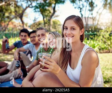 Die beste Zeit aller Zeiten. Beschnittenes Porträt einer attraktiven jungen Frau, die in der Sommersonne mit Freunden ein paar Drinks genießt. Stockfoto