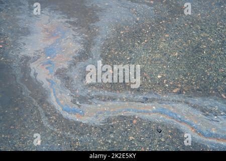 Verschmutzter mehrfarbiger Fleck vom Motoröl auf Asphalt Stockfoto