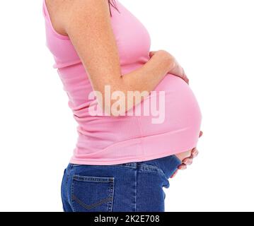 Shes erwartet. Abgeschnittene Aufnahme einer Schwangeren, isoliert auf Weiß. Stockfoto