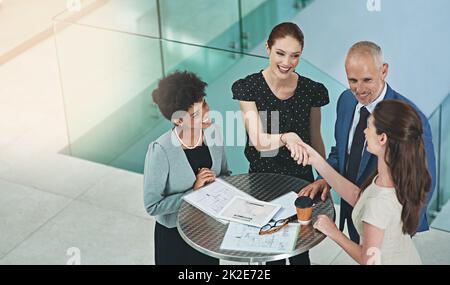 Bildung von Partnerschaften zur Stärkung des Geschäfts. Eine kurze Aufnahme einer Gruppe von Geschäftsleuten, die sich während einer Besprechung in einem Büro die Hände schüttelten. Stockfoto