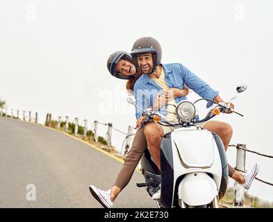 Die Lovebirds schlagen die Straße. Aufnahme eines abenteuerlichen Paares, das auf einem Motorrad unterwegs ist. Stockfoto