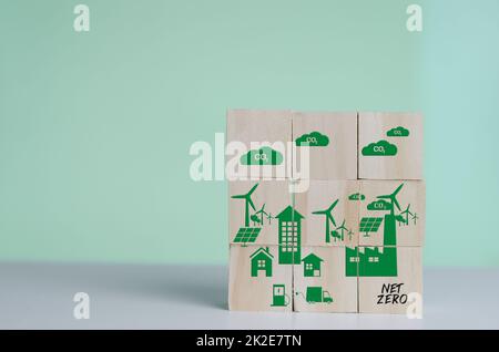 Holzwürfel mit Netto Null und Carbon neutral grün Fabrik Symbol Hintergrund und Copy Space. Stockfoto