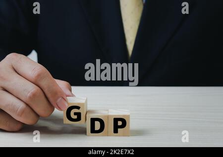 Hand legte Holzwürfel mit GDP Text Bruttoinlandsprodukt auf Tabelle copy space.Business Financial Management Economic Concepts. Stockfoto