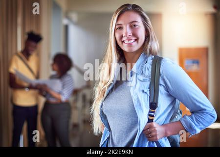 Erfolg beginnt mit der richtigen Einstellung. Porträt eines Studenten, der in einem Korridor auf dem Campus steht. Stockfoto