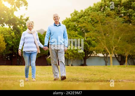 Spaziergang durch den Park. Porträt eines älteren Paares, das gemeinsam in einem Park spazieren geht. Stockfoto