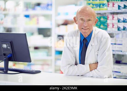 Ich habe viele Heilmittel gesehen, die kommen und gehen Porträt eines leitenden Apothekers, der an einer Theke arbeitet. Stockfoto