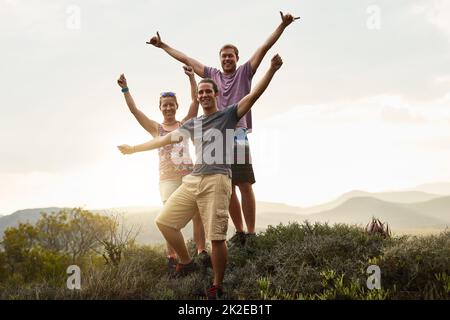 Geht mehr, macht euch weniger Sorgen. Portrait von drei glücklichen Freunden, die bei einer Wanderung in den Bergen zusammen posieren. Stockfoto