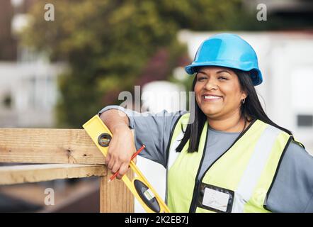 Ich habe alle Tools, die ich zum Erfolg brauche. Beschnittenes Porträt einer attraktiven jungen Bauarbeiterin, die auf der Baustelle arbeitet. Stockfoto