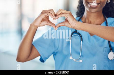 Herzhand und schwarze Frau Krankenschwester im Krankenhaus mit Ausdruck zu zeigen, Liebe und Sorge für die Karriere. Professionelle medizinische Einrichtung Arbeiter in Uniform mit Stockfoto