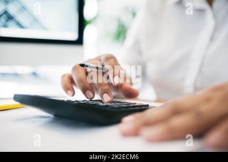 Was bedeutet das? Aufnahme eines nicht erkennbaren Geschäftsreisenden, der in einem Büro einen Taschenrechner benutzt. Stockfoto