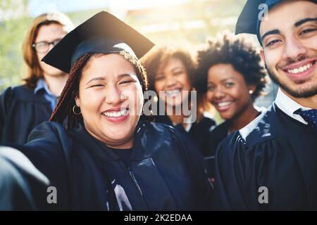 Wir hätten nicht glücklicher sein können, dass dieser Tag gekommen ist. Ausgeschnittene Aufnahme einer Gruppe von Studenten, die zusammen ein Selfie machen. Stockfoto