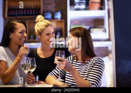 Es ist ein bisschen ein Weinkenner. Eine kurze Aufnahme von drei Frauen, die in einem Restaurant ein Glas Weißwein genießen. Stockfoto