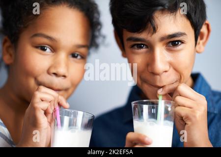 Kalzium für gesunde Knochen. Ein Bruder und eine Schwester trinken gemeinsam Milch. Stockfoto