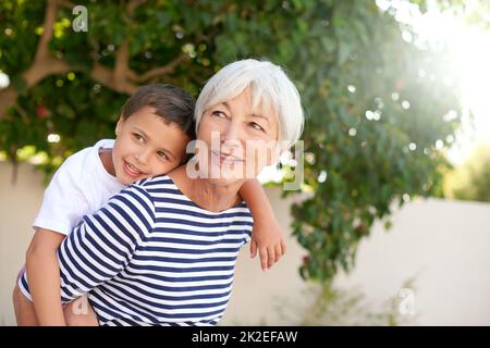 Bindung mit Oma. Ausgeschnittene Aufnahme einer älteren Frau, die sich mit ihrem Enkel verklebte. Stockfoto