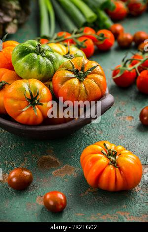 Auswahl an Tomaten, Salat und Sprotte auf grünem Hintergrund Stockfoto