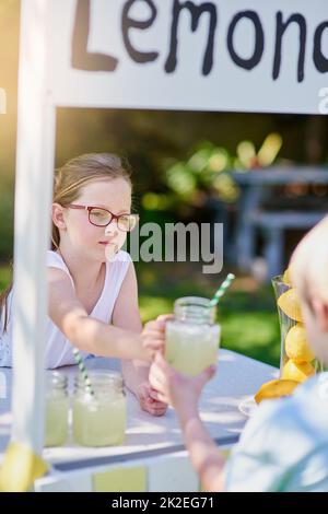 Die perfekte Erfrischung an einem heißen Sommertag. Ein kurzer Schuss eines kleinen Mädchens, das Limonade von ihrem Stand draußen verkauft. Stockfoto