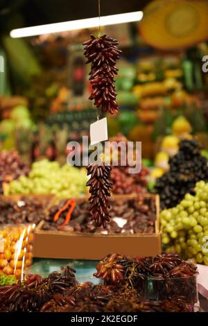 Trauben von köstlichen Trauben. Aufnahme von hängenden Trauben auf einem Markt. Stockfoto