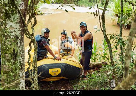 Waren bereit, etwas Rafting Spaß zu haben. Aufnahme einer Gruppe von Freunden beim Rafting an einem sonnigen Tag. Stockfoto