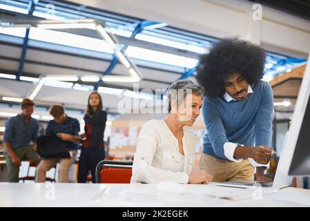 HES immer bereit, eine Hand zu geben. Eine kurze Aufnahme von zwei Designern, die in ihrem Büro an einem Computer arbeiten. Stockfoto