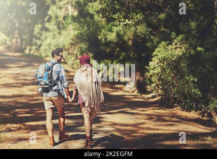 Wandern in die Wildnis. Rückansicht eines liebevollen jungen Paares während einer Wanderung. Stockfoto
