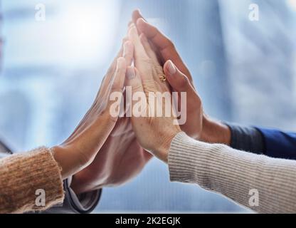 Gemeinsam können wir das tun. Aufnahme einer Gruppe von Geschäftsleuten, die sich gegenseitig hoch verfünffach. Stockfoto