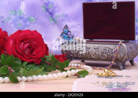 Rote Rosen mit Hochzeitsbändern und Schmuckkästchen Stockfoto