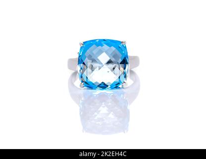 Polstergeschnittener blauer Topas-Ring auf weißem Hintergrund mit Reflektion. Kollektion von natürlichen Edelsteinen Accessoires. Studioaufnahme Stockfoto