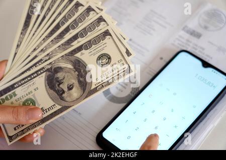 Anstieg der Preise für Energiekosten während der Finanzkrise. Frau Zählen Kosten Strom Rechnung oder Gas Rechnung auf Rechner. Stockfoto