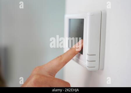 Energiesparen Konzept: Menschliche Hand Absenken der Temperatur auf dem Digitaldisplay Stockfoto