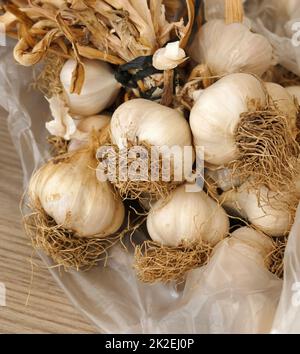 Ein Haufen getrockneter Knoblauch - viele getrocknete Knoblauchköpfe, Nahaufnahme getrockneter Knoblauch in einem Haufen Stockfoto