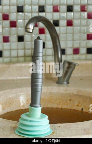 Verwenden einer Küchenpumpe aus Kunststoff, um das Spülbecken zu reinigen Stockfoto