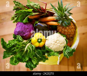 Holen Sie sich Ihre Grüns. Aufnahme einer Auswahl an Obst und Gemüse in einer Einkaufstasche. Stockfoto